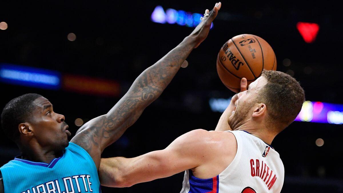 Clippers forward Blake Griffin, right, shoots as Charlotte Hornets forward Marvin Williams defends during the first half Sunday.