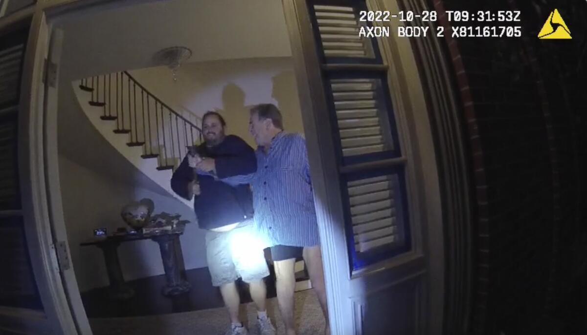 An image from an officer's body camera shows David DePape, left, fighting for a hammer with Paul Pelosi in Pelosi's home
