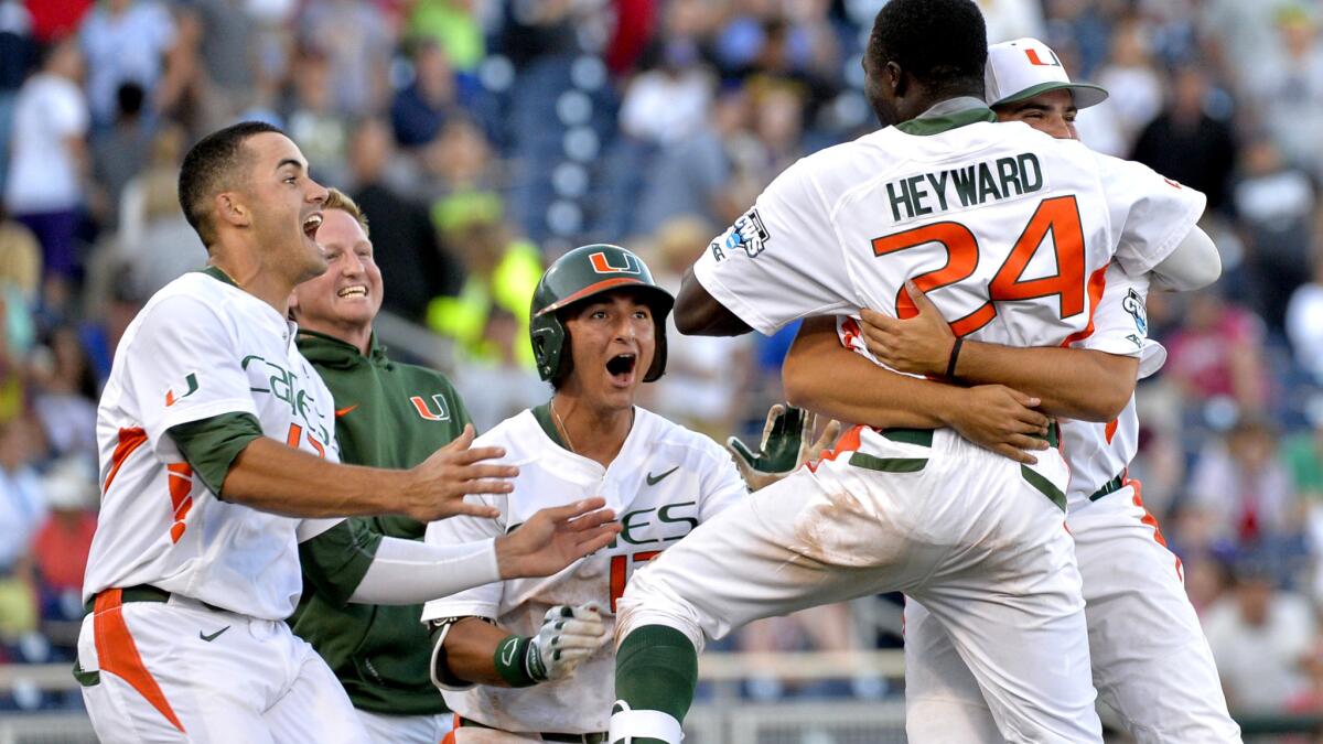 Miami's Jacob Heyward (24) celebrates with teammates after driving in the winning run against Arkansas in an elimination game at the College World Series on Monday in Omaha.