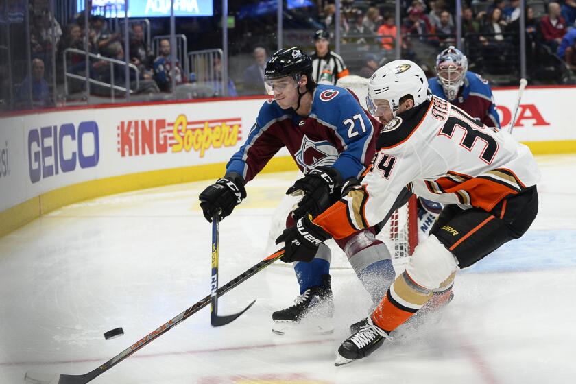 Avalanche defenseman Ryan Graves and Ducks center Sam Steel chase a puck into a corner during the second period of a game March 4 at the Pepsi Center.