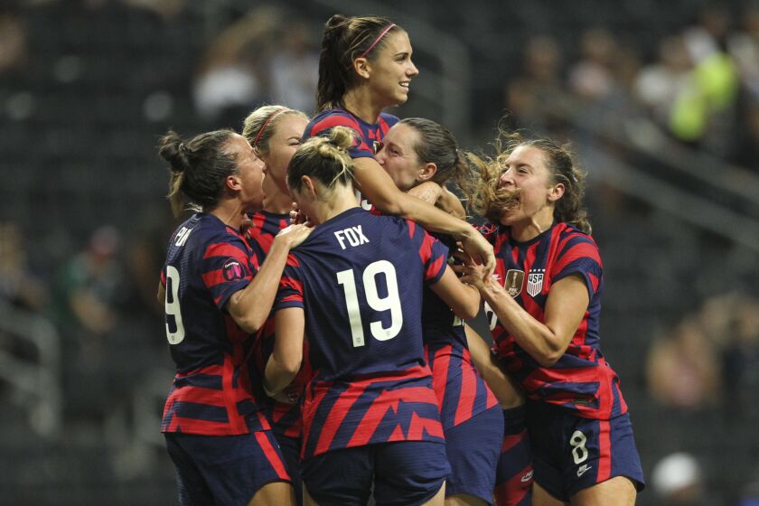United States' Alex Morgan, top, is congratulated after scoring her side's opening goal from the penalty spot against Canada during the CONCACAF Women's Championship final soccer match in Monterrey, Mexico, Monday, July 18, 2022. (AP Photo/Roberto Martinez)