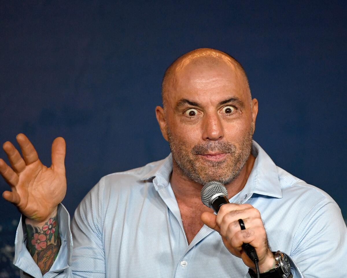 A wide-eyed Joe Rogan holding a microphone