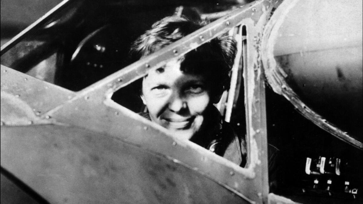 An undated 1930s photo shows U.S. aviator Amelia Earhart looking through the cockpit window of an aircraft in Essonne, France. A Burbank reader seconds an earlier suggestion that David Starr Jordan Middle School be renamed in Earhart's honor.
