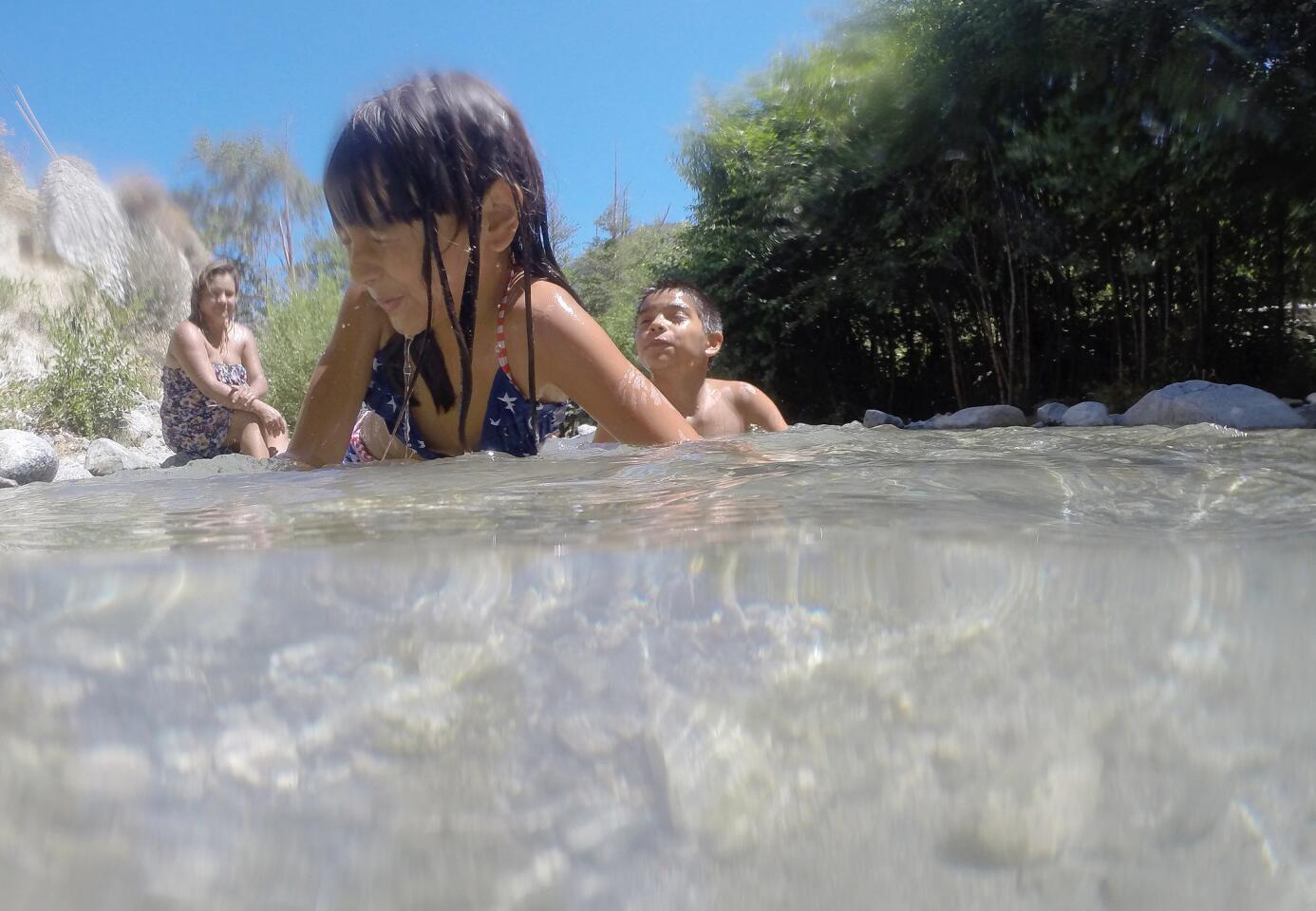 With temperatures scorching to 106 degrees, Kimberly Fuentes, 6, and her brother Anthony Villanueva, 11, of Riverside cool off in Lytle Creek, Calif.