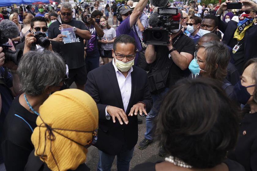 FILE - Minnesota Attorney General Keith Ellison, center, speaks with Rep. Ilhan Omar, D-Minn., and members of the Congressional Black Caucus as they visit the site of George Floyd's death in south Minneapolis on June 4, 2020. (Anthony Souffle/Star Tribune via AP, File)