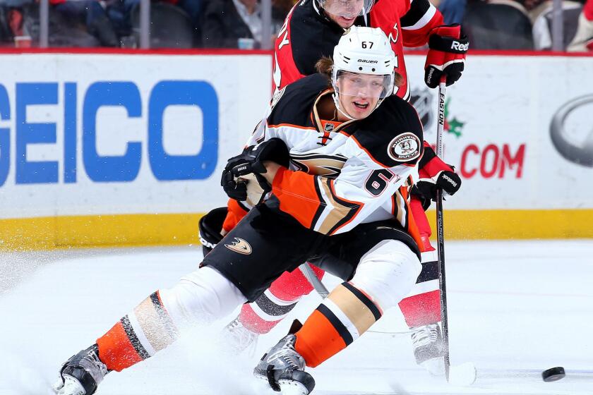 Ducks center Rickard Rakell tries to beat Devils center Tyler Kennedy to the puck during their game Saturday.