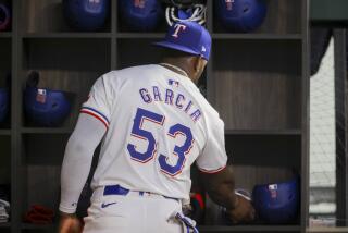 El cubano Adolis García, de los Rangers de Texas, prepara su equipamiento antes del juego ante los Marineros de Seattle, el miércoles 24 de abril de 2024 (AP Foto/Gareth Patterson)