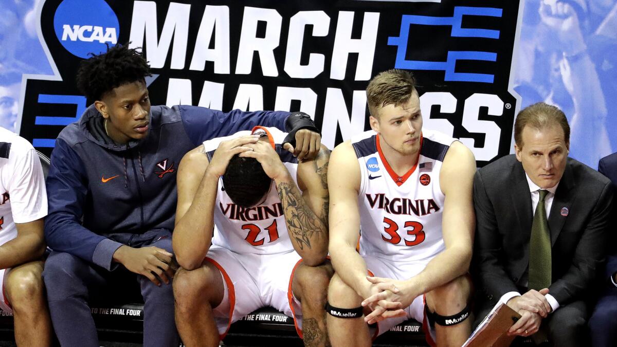 Virginia's Isaiah Wilkins (21) is consoled after fouling out during the second half of the upset loss to UMBC on Friday.