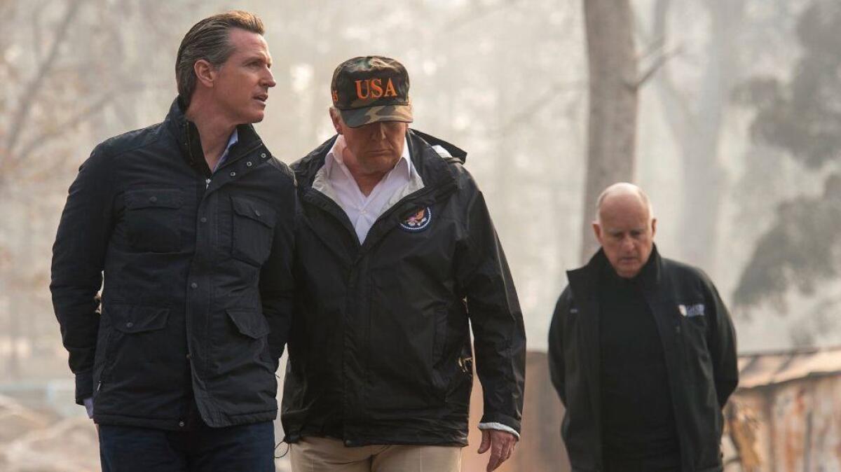 President Trump talks to then-Governor-elect Gavin Newsom during a visit on Nov. 17 to a Paradise neighborhood destroyed in the Camp fire. At right is then-Gov. Jerry Brown.