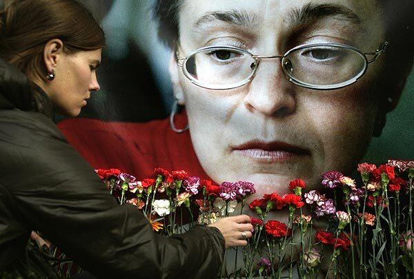 A woman pays tribute before a portrait of slain journalist Anna Politkovskaya in the Russian capital. Hundreds attended a rally marking the third anniversary of the investigative journalist's death.