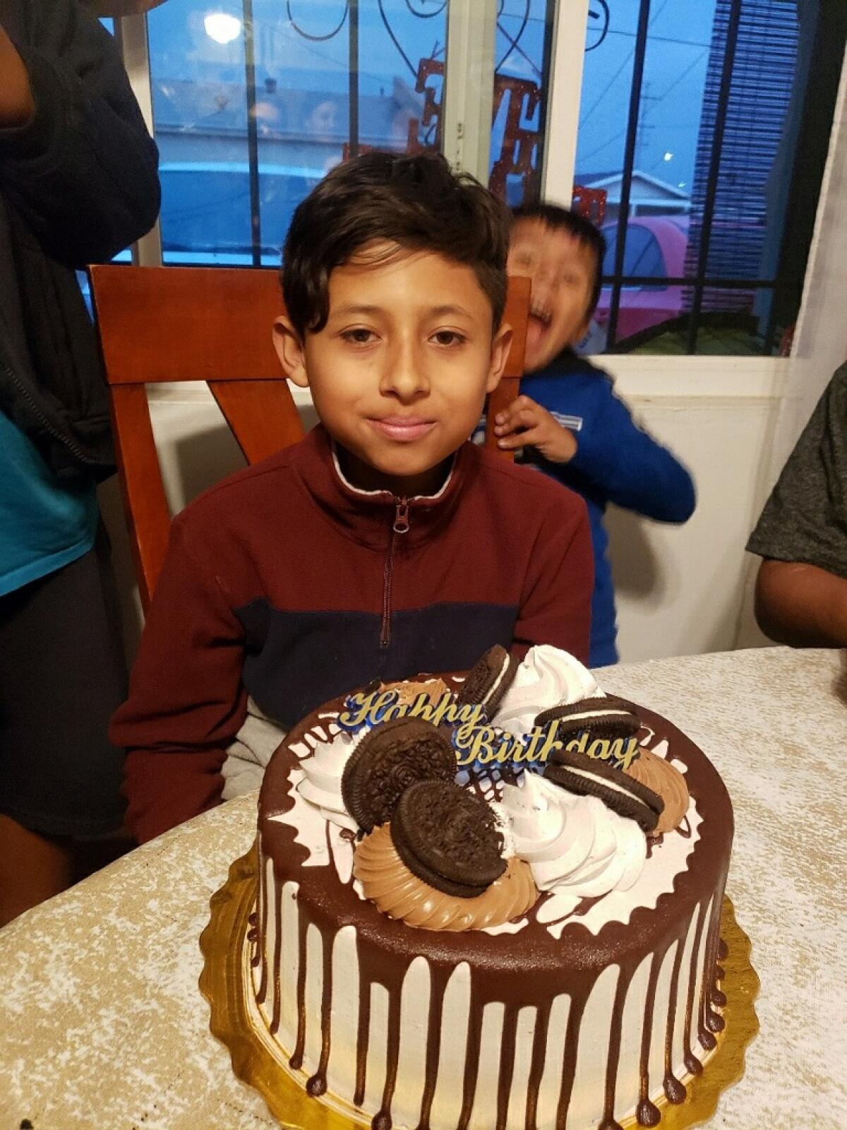 Angel Domingo Gaspar Gallegos smiles by a birthday cake