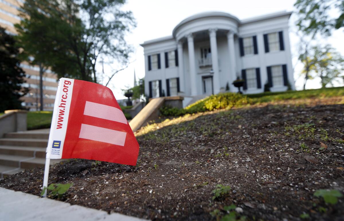 A Human Rights Campaign equality flag is planted at the edge of the grounds of the governor's mansion in Jackson, Miss.
