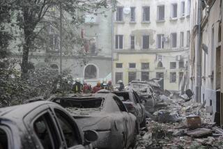 Emergency service workers gather outside damaged buildings as search for victims continues following a Russian missile attack in Lviv, Ukraine, Thursday, July 6, 2023. (AP Photo/Mykola Tys)