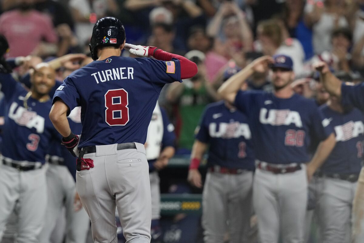 U.S. 's Trea Turner (8) salutes his teammates after hitting a home run during the second inning of a World Baseball Classic final game against Japan, Tuesday, March 21, 2023, in Miami. (AP Photo/Marta Lavandier)