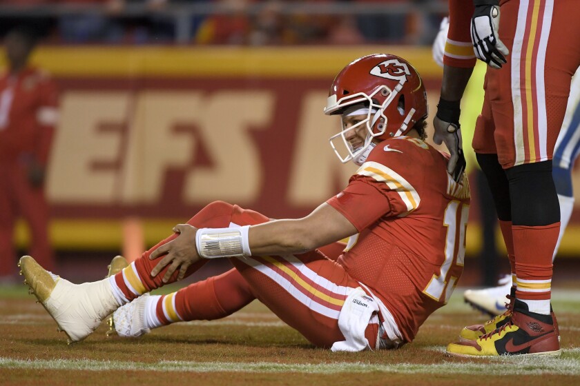 Kansas City Chiefs quarterback Patrick Mahomes holds his leg after he was tackled by Indianapolis Colts defensive ends Kemoko Turay and Justin Houston during the second half of Sunday's game.