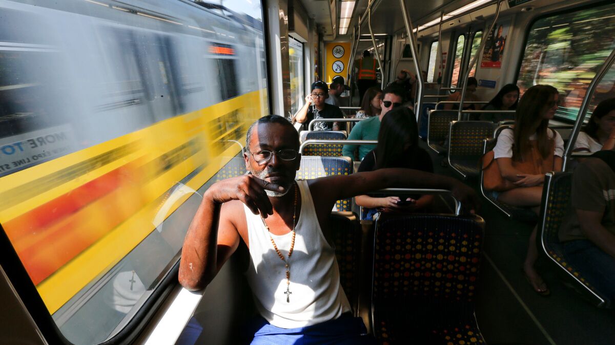 Jules Watkins of Los Angeles rides a Metro Expo Line train. Transportation registered broad job gains in August.