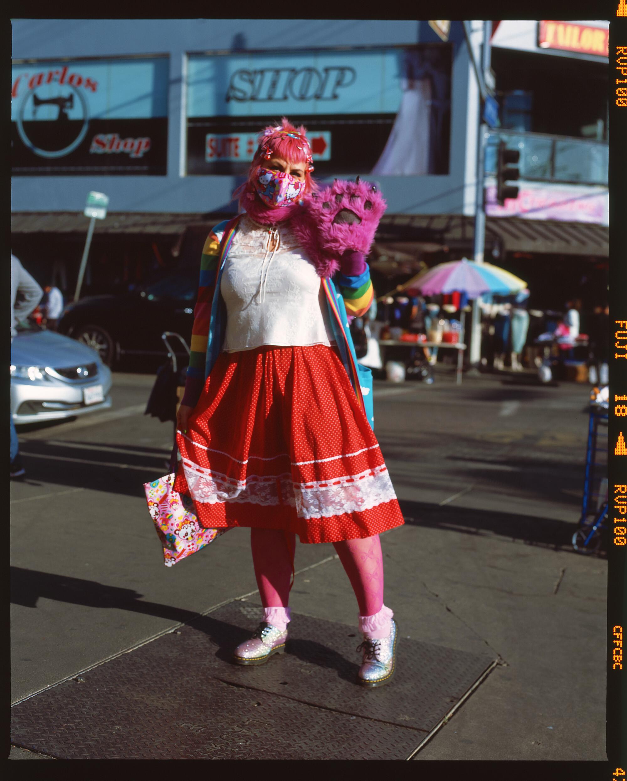 A person in a red dress stands for a photo.