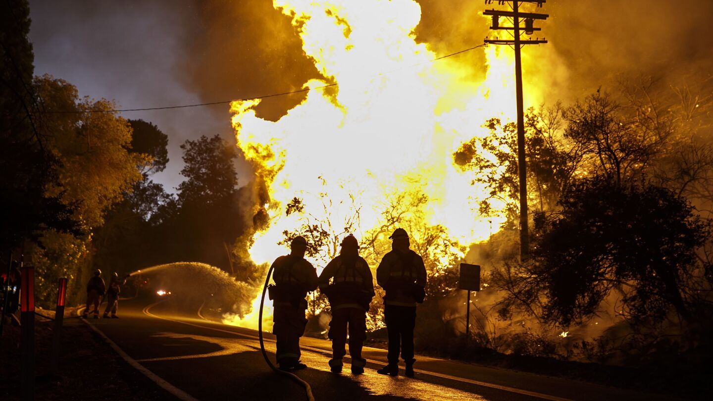 Firefighters attack the Blue Cut fire as it burns along Lytle Creek Road on Wednesday night.