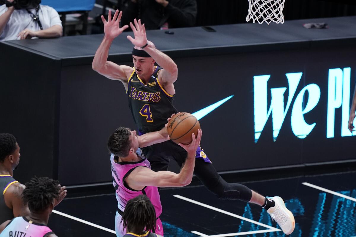 Los Angeles Lakers guard Alex Caruso (4) fouls Miami Heat guard Goran Dragic (7).