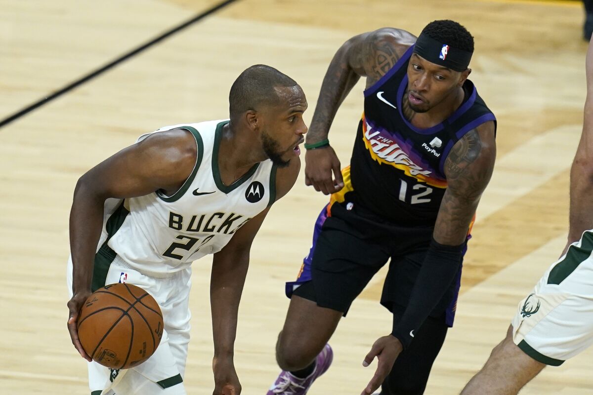 Milwaukee Bucks forward Khris Middleton dribbles the ball against Phoenix Suns forward Torrey Craig.