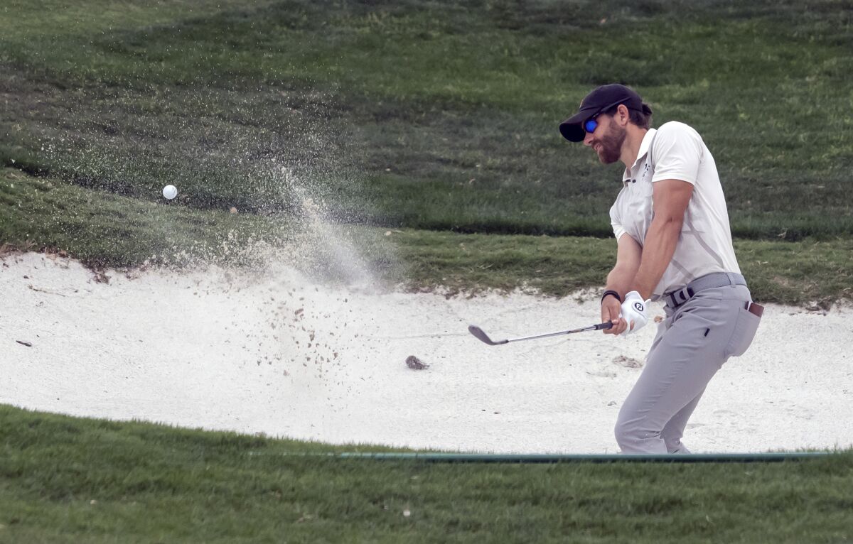 Patrick Rodgers hits out of a bunker on the 18th hole during the third round of the Valero Texas Open golf tournament in San Antonio, Saturday, April 1, 2023. (AP Photo/Michael Thomas)