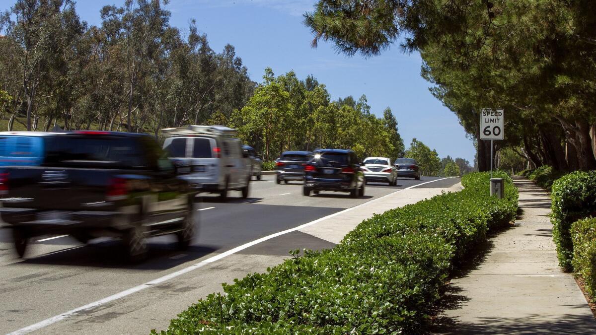 Vehicles travel past a 60 mph speed limit sign on Newport Coast Drive on Thursday.