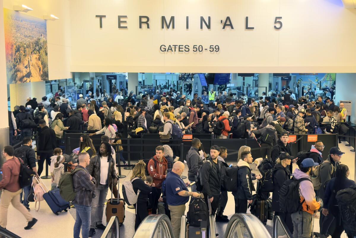 Travelers line up to go through an airport security checkpoint