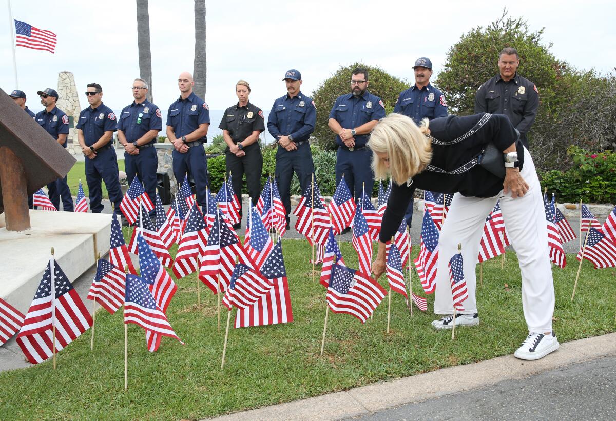 Laguna Beach fire personnel, with Chief Niko King, far right, stand around the "Semper Memento" sculpture on Wednesday.