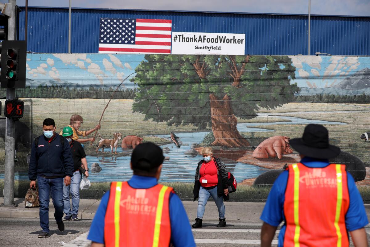 Los trabajadores salen de la planta Farmer John, propiedad de Smithfield Foods en Vernon.