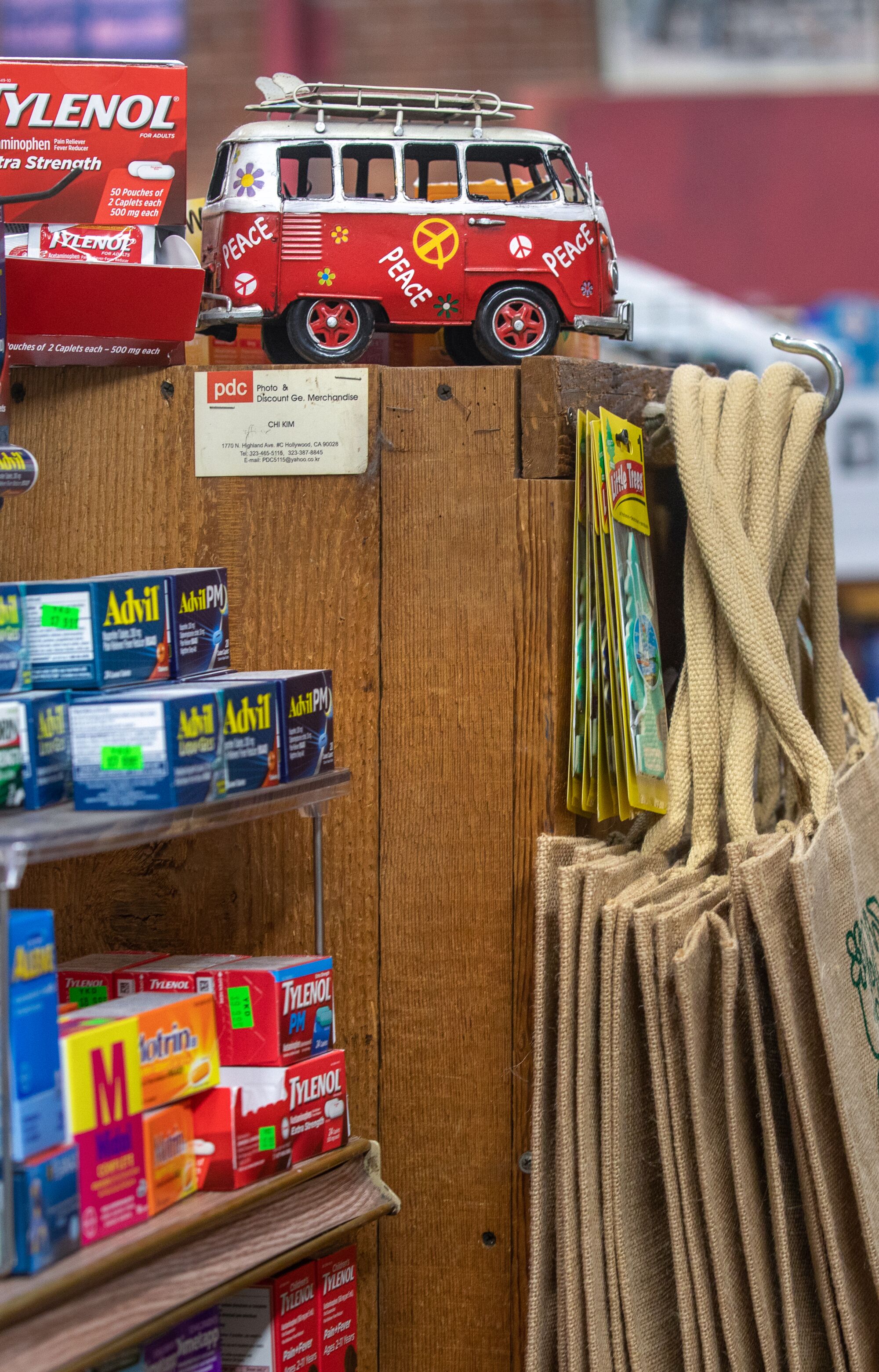 A miniature red van, reminiscent of those from the 1960s, is tucked between medication and tote bags.