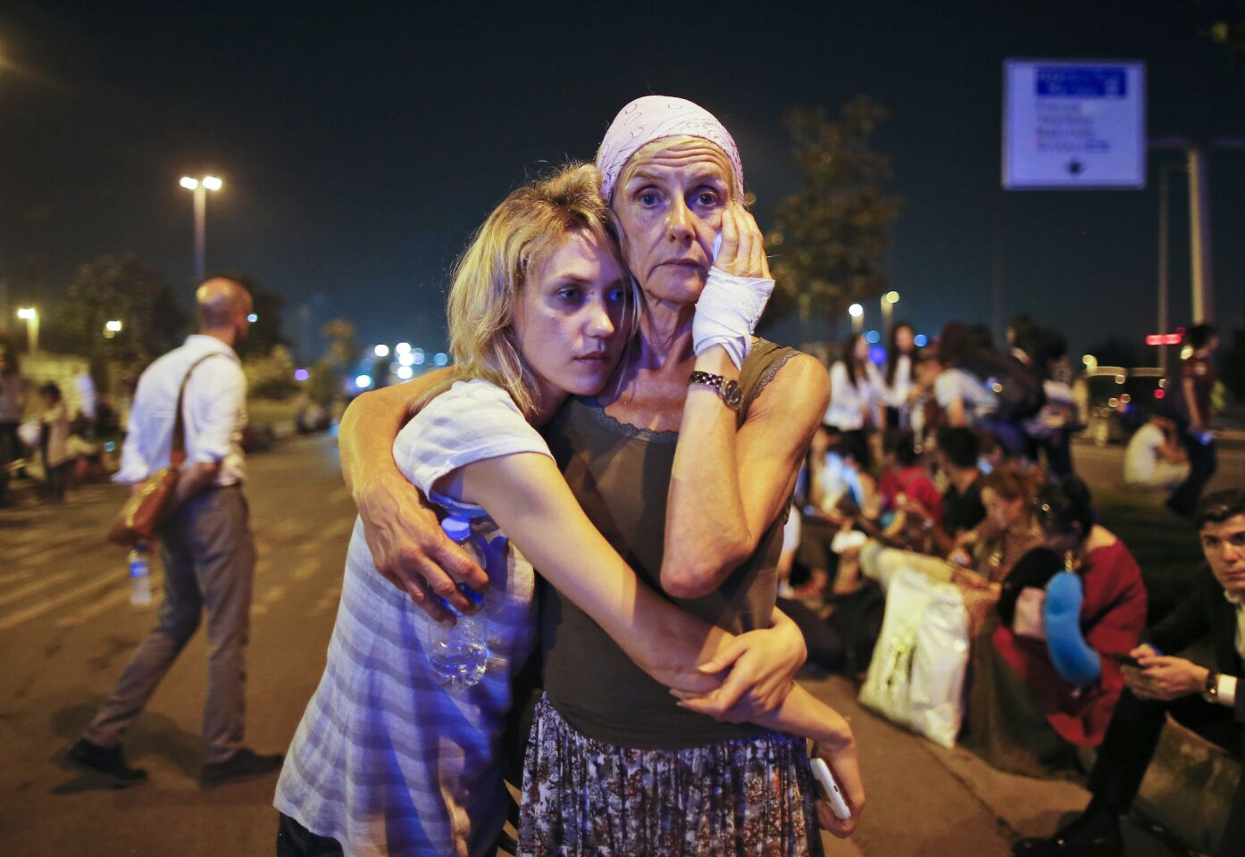 Passengers embrace outside Istanbul's Ataturk airport after being evacuated following a blast.