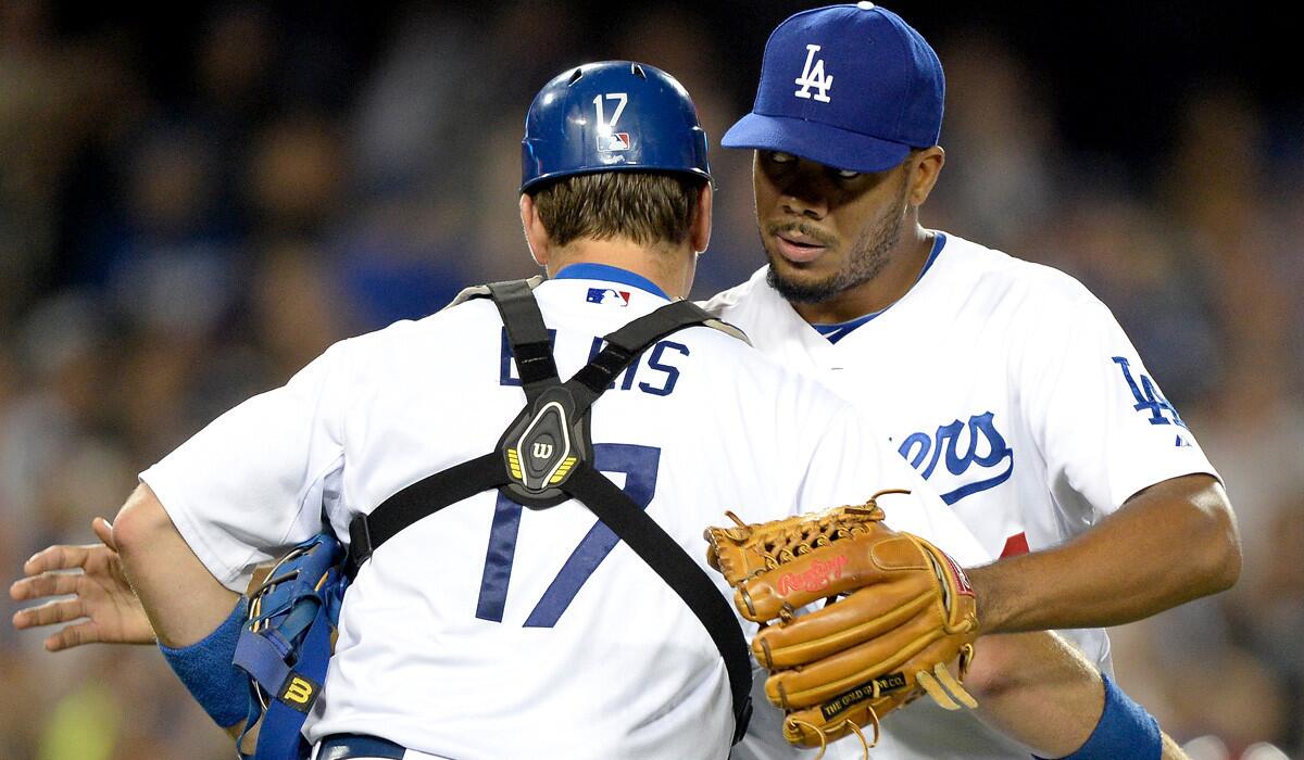 Dodgers catcher A.J. Ellis congratulates closer Kenley Jansen, who pitched a 1-2-3 ninth inning against the Diamondbacks on Friday night to earn his 40th save of the season.