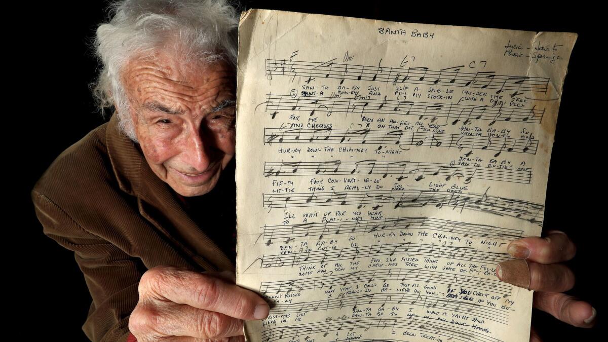 Songwriter Philip Springer, 91, holds up the original sheet of music and lyrics for the song "Santa Baby," which he co-wrote in August 1953. https://lat.ms/2zhQBcY