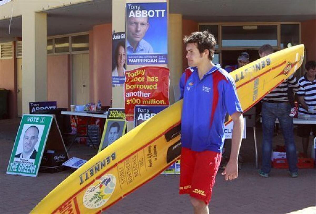 Surf lifesaver Brian Rignall walks past the Queenscliff Beach polling center in Sydney, Australia, Saturday, Aug. 21, 2010. Australians go to the polls Saturday to vote in the federal election. (AP Photo/Rob Griffith)