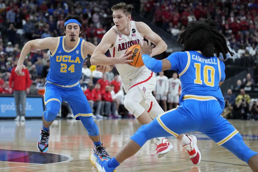 Arizona's Azuolas Tubelis (10) drives agaonst UCLA's Jaime Jaquez Jr. (24) during the first half.