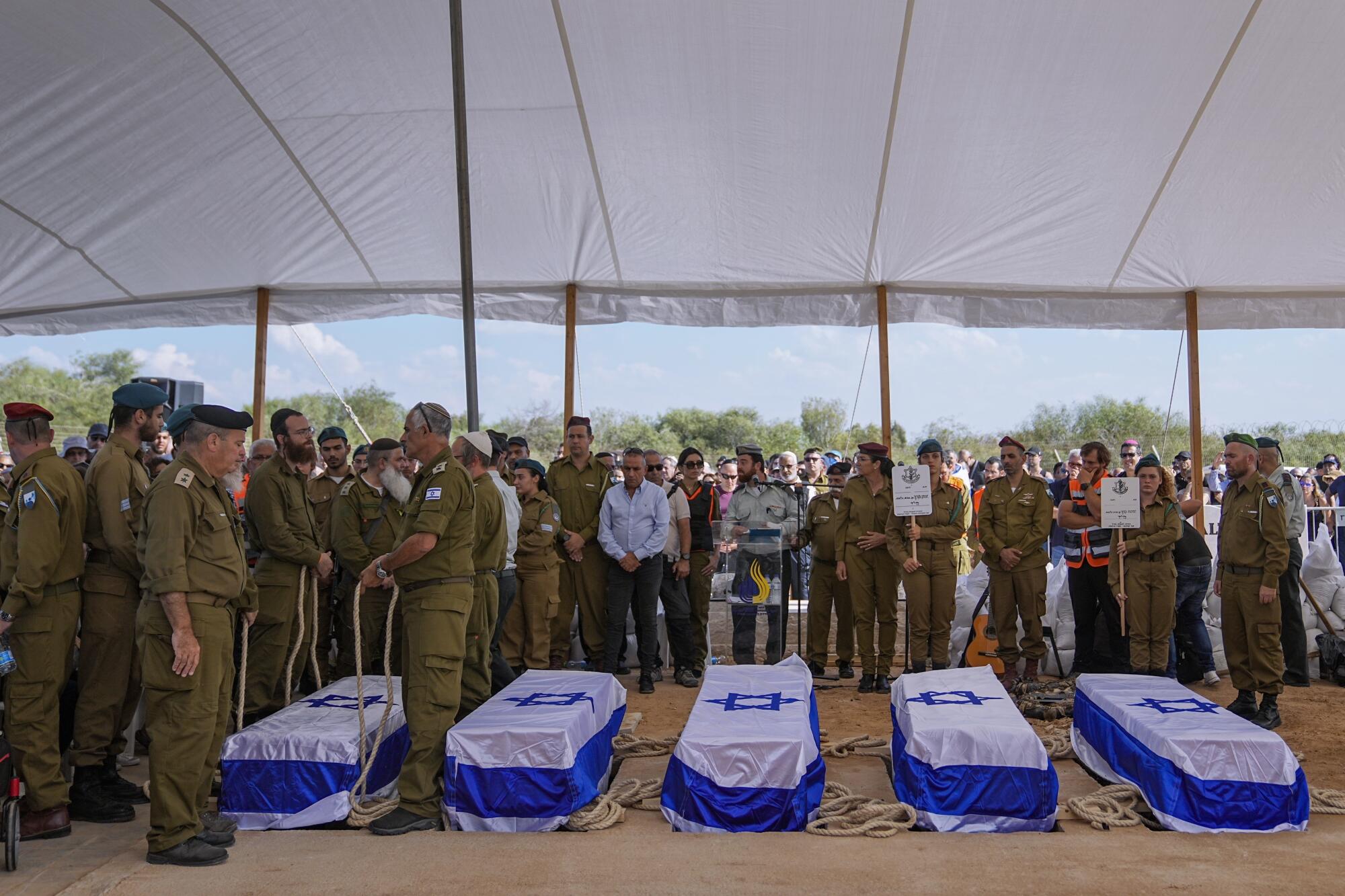 Mourners gathered around five coffins in Gan Yavne, Israel