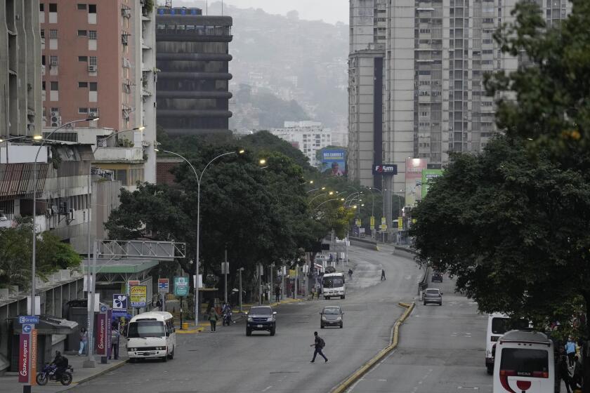 A man crosses an avenue in Caracas, Venezuela, Monday, July 29, 2024, the day after the presidential election. (AP Photo/Matias Delacroix)