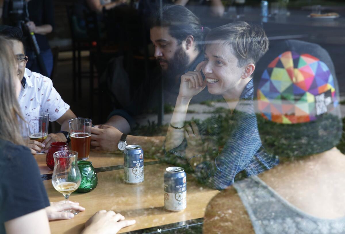 Diana Downard, de 26 años y seguidora de Bernie Sanders que dice que votará a Hillary Clinton, toma unos tragos con amigos en un pub en Denver, el 6 de julio de 2016. "Los millennials han sido descritos como apáticos, pero no lo son", dijo Downard. (AP Foto/Brennan Linsley)