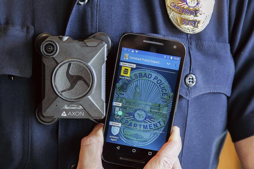 A member of the Carlsbad Police Department shows a body camera and accompanying phone app all members of the department are to use in Carlsbad, Calif., on Nov. 1, 2016. Despite laws intended to “pierce the secrecy” protecting California police officers, law enforcement agencies have thwarted those who seek information on cases of alleged misconduct – in some instances battling requesters in court. (Eduardo Contreras/The San Diego Union-Tribune via AP)