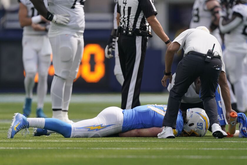 Los Angeles Chargers linebacker Joey Bosa, bottom, is tended to during the first half of an NFL football game against the Jacksonville Jaguars in Inglewood, Calif., Sunday, Sept. 25, 2022. (AP Photo/Mark J. Terrill)