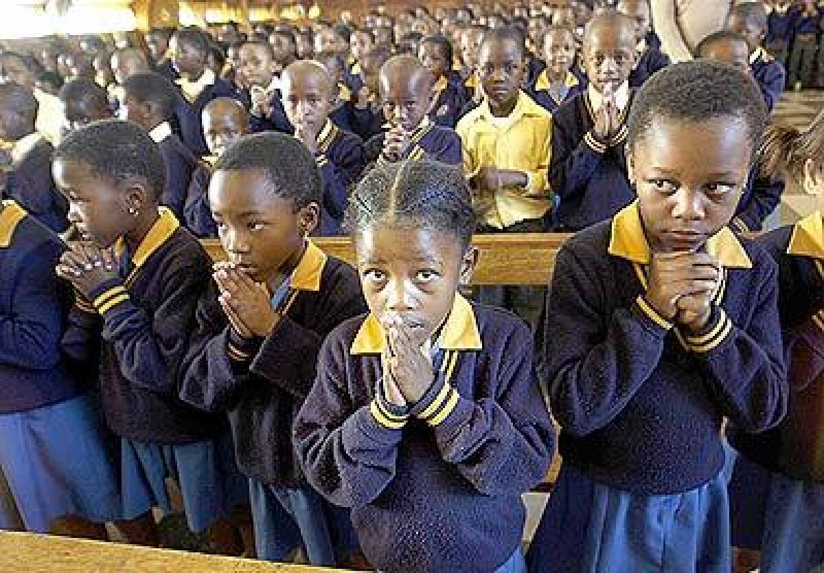 AT MASS: Schoolchildren in Soweto, South Africa, pray for the pope. The continent has more than 130 million Catholics.