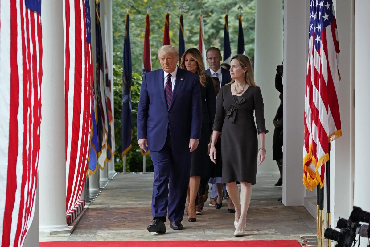 President Trump walks with Judge Amy Coney Barrett.