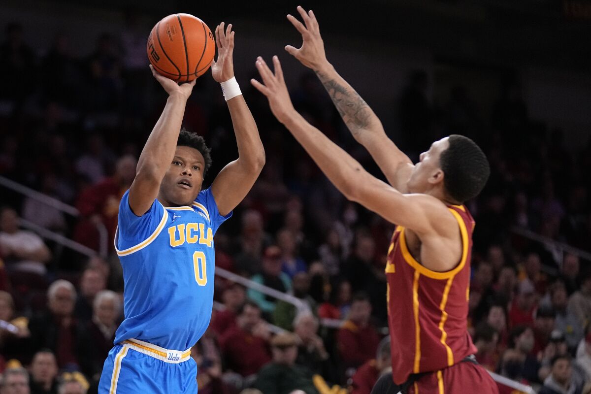 Le garde de l'UCLA Jaylen Clark, à gauche, tire alors que l'attaquant de l'USC Kobe Johnson défend pendant la première mi-temps jeudi.