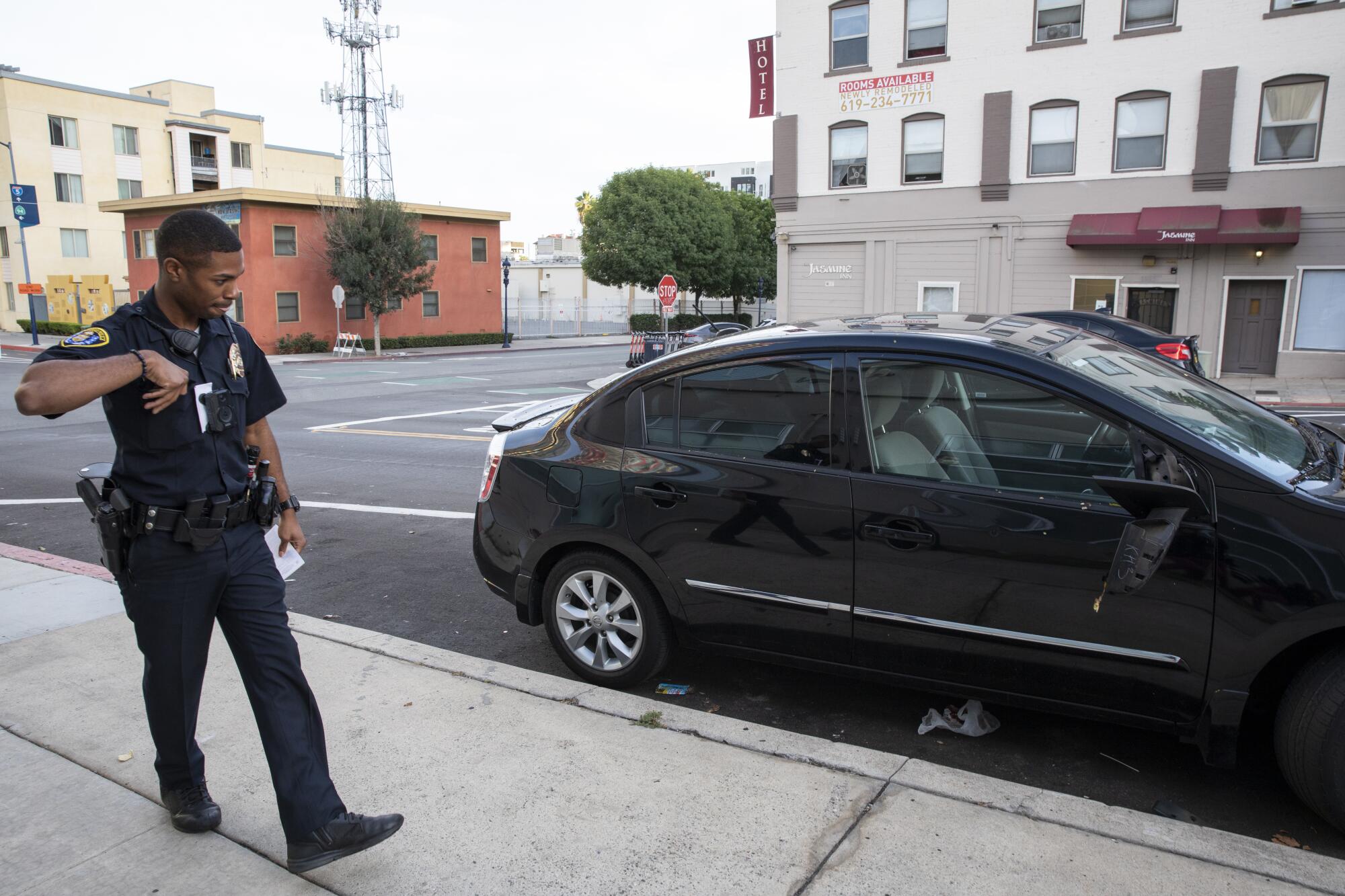 San Diego police officer Jordan Williams investigates an incident where about 12 cars were damaged.