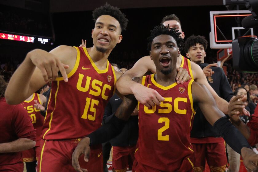 LOS ANGELES, CA - MARCH 7, 2020: USC Trojans guard Jonah Mathews (2) is swarmed by teammates USC Trojans forward Isaiah Mobley (15) and USC Trojans forward Nick Rakocevic (31) after scoring the game winning 3-point shot to beat UCLA in the final moments at Galen Center on March 7, 2020 in Los Angeles, California. (Gina Ferazzi/Los AngelesTimes)
