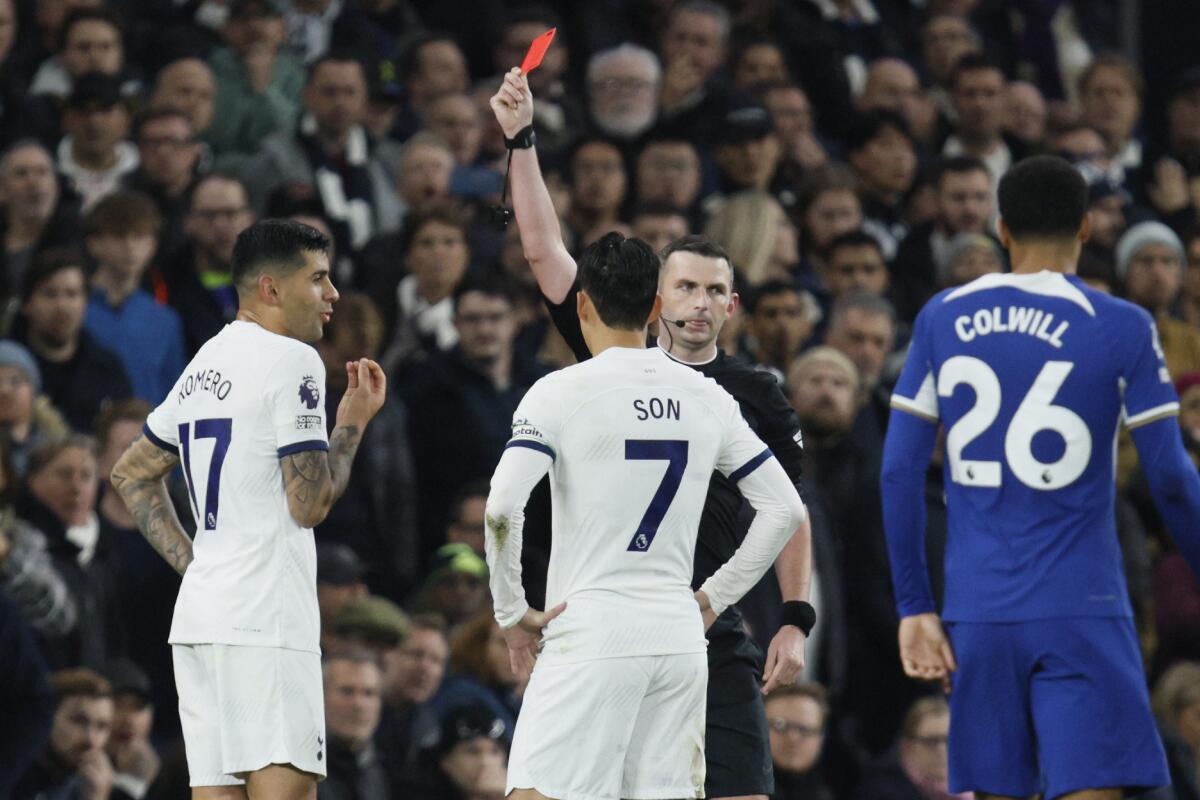 El árbitro Michael Oliver le muestra una tarjeta roja a Cristian Romero del Tottenham 