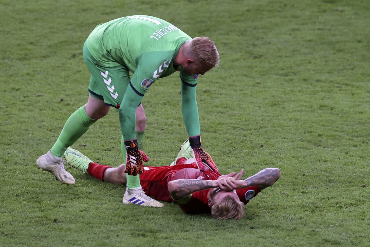 Denmark's goalkeeper Kasper Schmeichel checks on teammate Simon Kjaer at the end of the Euro 2020 soccer championship semifinal match between England and Denmark at Wembley stadium in London, Wednesday, July 7, 2021. England won 2-1. (Catherine Ivill/Pool Photo via AP)