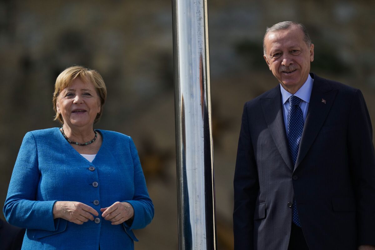 German Chancellor Angela Merkel, left, is welcomed by Turkish President Recep Tayyip Erdogan on the occasion of their meeting at Huber Villa presidential palace, in Istanbul, Turkey, Saturday, Oct. 16, 2021. (AP Photo/Francisco Seco)