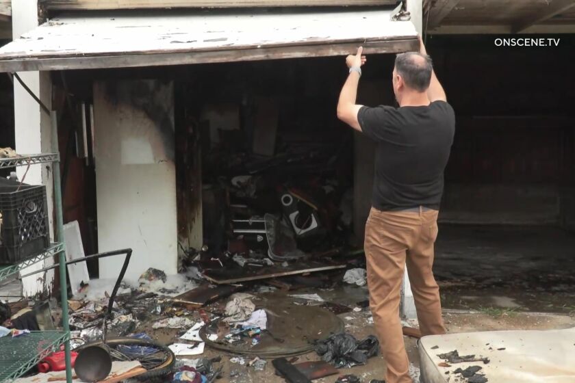 A man looks inside a garage after fire crews doused a fire