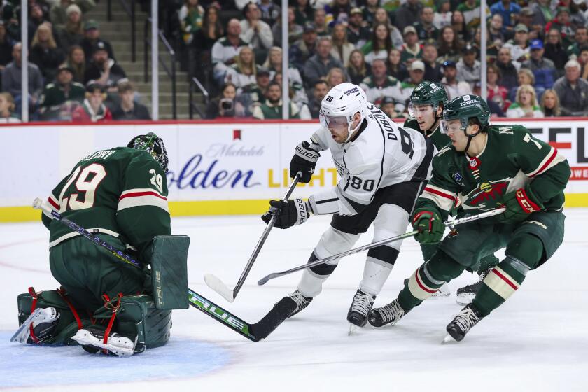 Los Angeles Kings center Pierre-Luc Dubois, second from left, scores a goal against Minnesota Wild goaltender Marc-Andre Fleury (29) while Wild defenseman Brock Faber (7) defends during the first period of an NHL hockey game Thursday, Oct. 19, 2023, in St. Paul, Minn. (AP Photo/Matt Krohn)